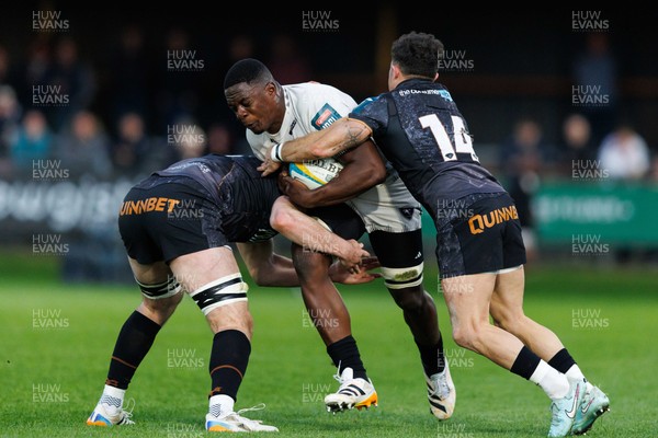 180426 - Ospreys v Hollywoodbets Sharks - United Rugby Championship - Manu Tshituka of Sharks is tackled by James Ratti and Luke Morgan of Ospreys