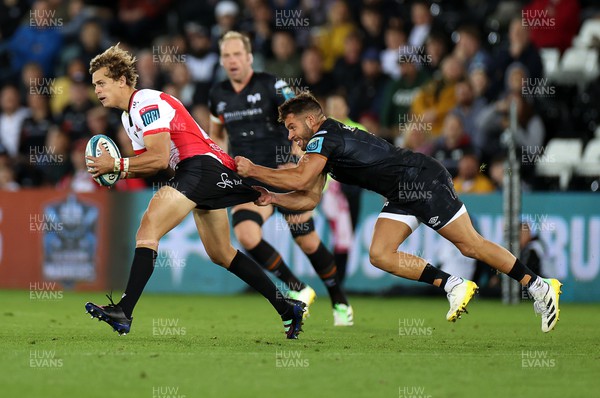 240922 - Ospreys v Lions - United Rugby Championship - Andries Coetzee of Lions is tackled by Rhys Webb of Ospreys