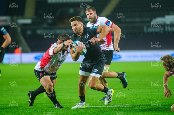 240922 - Ospreys v Emirates Lions - United Rugby Championship - Rhys Webb of Ospreys evades the tackle of Ruan Dreyer of Lions