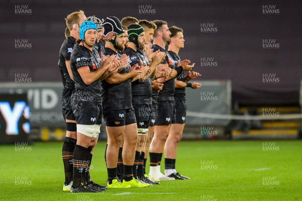 240922 - Ospreys v Emirates Lions - United Rugby Championship - Players pause to remember former BBC journalist, Pontypool and Wales captain Eddie Butler