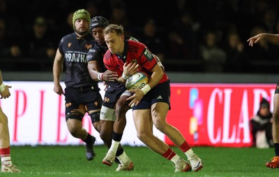 201225 - Ospreys v Munster, United Rugby Championship - Mike Haley of Munster is held by Dan Kasende of Ospreys