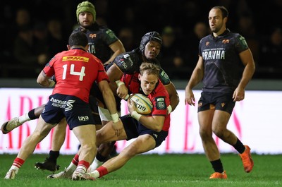 201225 - Ospreys v Munster, United Rugby Championship - Mike Haley of Munster is held by Dan Kasende of Ospreys