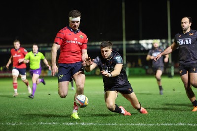 201225 - Ospreys v Munster, United Rugby Championship - Shane Daly of Munster kicks the ball clear to deny Max Nagy of Ospreys the chance to score