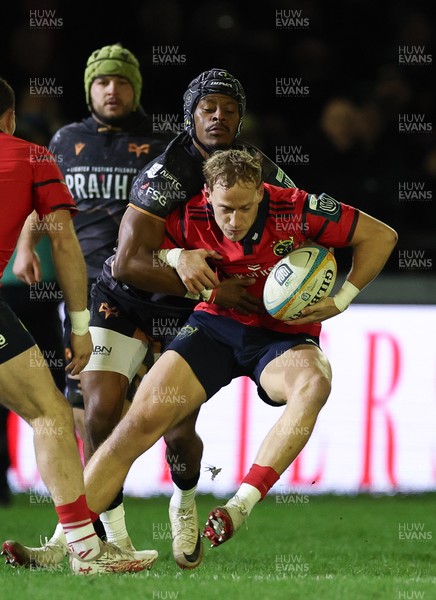 201225 - Ospreys v Munster, United Rugby Championship - Mike Haley of Munster is held by Dan Kasende of Ospreys