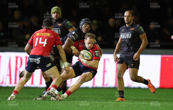 201225 - Ospreys v Munster, United Rugby Championship - Mike Haley of Munster is held by Dan Kasende of Ospreys