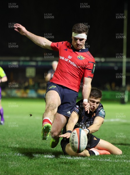 201225 - Ospreys v Munster, United Rugby Championship - Shane Daly of Munster kicks the ball clear to deny Max Nagy of Ospreys the chance to score