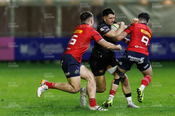 201225 - Ospreys v Munster - United Rugby Championship - Owen Watkin of Ospreys is tackled by Mike Haley and Paddy Patterson of Munster