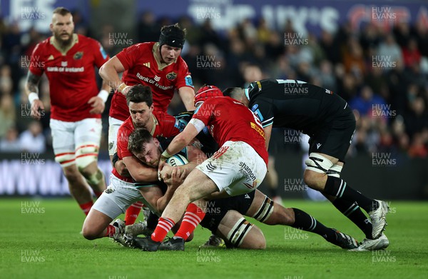 220324 - Ospreys v Munster - United Rugby Championship - James Ratti of Ospreys is tackled by Joey Carbery and John Hodnett of Munster 
