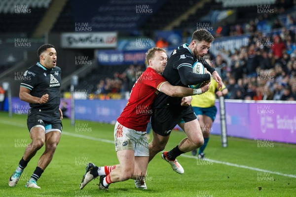220324 - Ospreys v Munster - United Rugby Championship - Alex Cuthbert of Ospreys is tackled by Mike Haley of Munster