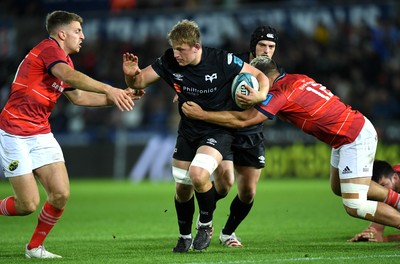 231021 - Ospreys v Munster - United Rugby Championship - Jac Morgan of Ospreys takes on Dan Goggin and Liam Coombes of Munster