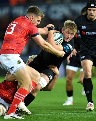 231021 - Ospreys v Munster - United Rugby Championship - Jac Morgan of Ospreys takes on Dan Goggin and Liam Coombes of Munster