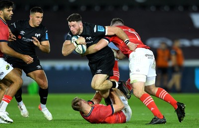 231021 - Ospreys v Munster - United Rugby Championship - Alex Cuthbert of Ospreys is tackled by Jack Crowley and Peter O’Mahony of Munster