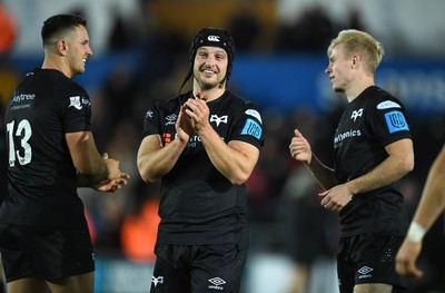 231021 - Ospreys v Munster - United Rugby Championship - Owen Watkin, Dan Evans and Mat Protheroe of Ospreys at the end of the game