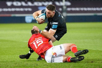 231021 - Ospreys v Munster - United Rugby Championship - Alex Cuthbert of Ospreys is tackled by Matt Gallagher of Munster