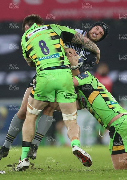 171217 - Ospreys v Northampton Saints - European Rugby Champions Cup - Dan Evans of Ospreys is tackled by Tom Wood and Mikey Haywood of Northampton