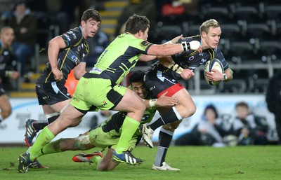 180115 - Ospreys v Northampton Saints - European Rugby Champions Cup -Hanno Dirksen of Ospreys is tackled by Calum Clark and George Pisi of Northampton