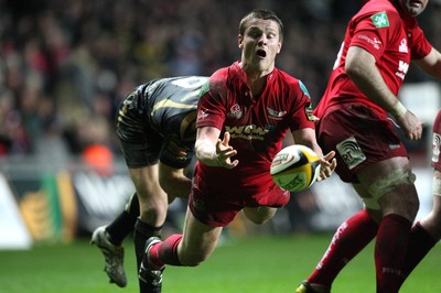 02.04.10 ... Ospreys v Scarlets, Magners League -  Tavis Knoyle of Scarlets feeds the ball out under pressure from Mike Phillips of Ospreys 