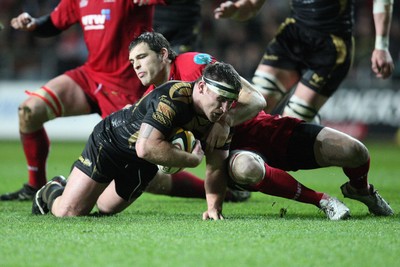 02.04.10 ... Ospreys v Scarlets, Magners League -  Huw Bennett of Ospreys is tackled by Sean Lamont of Scarlets 