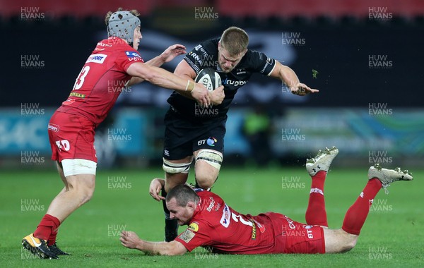 071017 - Ospreys v Scarlets - Guinness PRO14 - Olly Cracknell of Ospreys is tackled by Jonathan Davies and Ken Owens of Scarlets