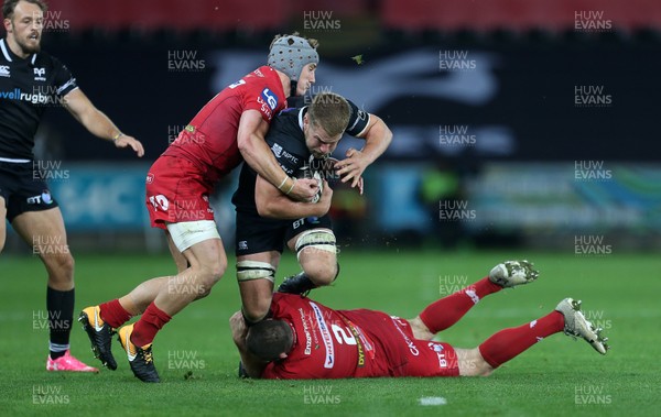 071017 - Ospreys v Scarlets - Guinness PRO14 - Olly Cracknell of Ospreys is tackled by Jonathan Davies and Ken Owens of Scarlets