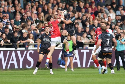 090526 - Ospreys v Scarlets - United Rugby Championship - Tom Rogers of Scarlets and Jack Walsh of Ospreys go up for the ball