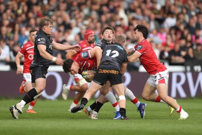090526 - Ospreys v Scarlets - United Rugby Championship - Eddie James of Scarlets is tackled by Keiran Williams of Ospreys 