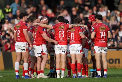090526 - Ospreys v Scarlets - United Rugby Championship - Scarlets team huddle under the posts