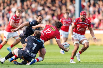 090526 - Ospreys v Scarlets - United Rugby Championship - Eddie James of Scarlets offloads the ball to Josh Macleod of Scarlets