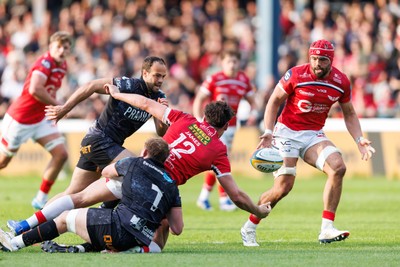 090526 - Ospreys v Scarlets - United Rugby Championship - Eddie James of Scarlets offloads the ball to Josh Macleod of Scarlets