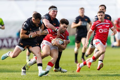 090526 - Ospreys v Scarlets - United Rugby Championship - Joe Roberts of Scarlets is tackled by Luke Morgan and Ryan Smith of Ospreys