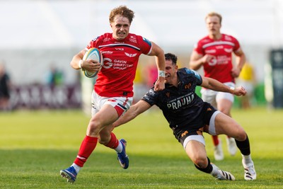 090526 - Ospreys v Scarlets - United Rugby Championship - Macs Page of Scarlets is tap-tackled by Owen Watkin of Ospreys