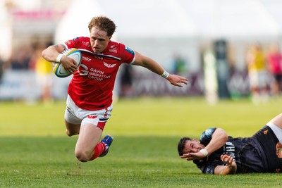 090526 - Ospreys v Scarlets - United Rugby Championship - Macs Page of Scarlets is tap-tackled by Owen Watkin of Ospreys
