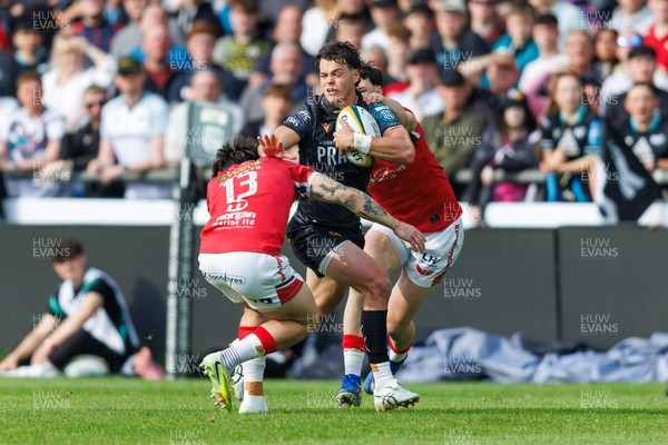 090526 - Ospreys v Scarlets - United Rugby Championship - Jack Walsh of Ospreys is tackled by Joe Roberts and Tom Rogers of Scarlets