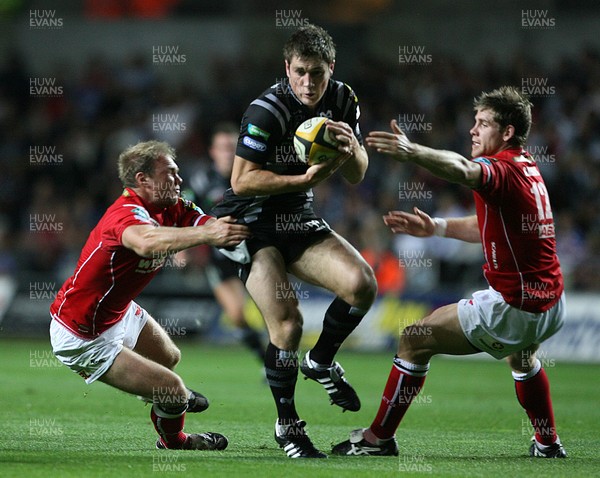 11.09.07 Ospreys v Scarlets... Ospreys Andrew Bishop is tackled by Ceiron Thomas and GavinEvans 