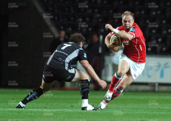 11.09.07 - Magners League Rugby Ospreys v Llanelli Scarlets Scarlets' Ceirion Thomas tries to beat a tackle from Ospreys' Ben Lewis 