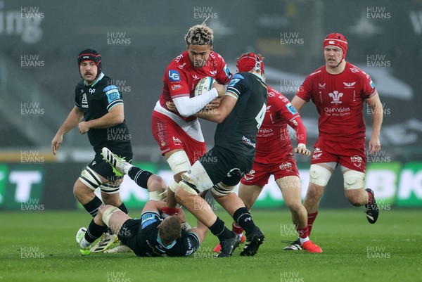 261123 - Ospreys v Scarlets - United Rugby Championship - Vaea Fifita of Scarlets is tackled by Jac Morgan and James Fender of Ospreys