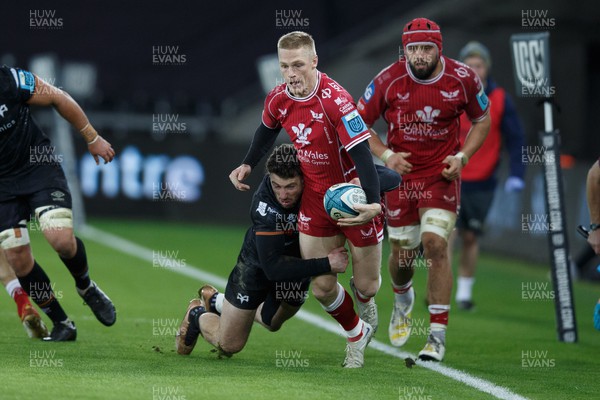 261222 - Ospreys v Scarlets - United Rugby Championship - Johnny McNicholl of Scarlets is tackled by Alex Cuthbert of Ospreys