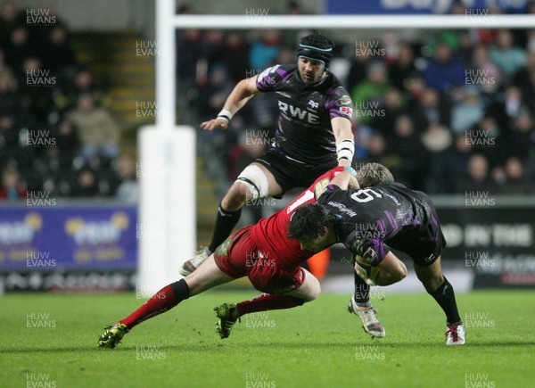 27.12.10 Ospreys v Scarlets... Mike Phillips of Ospreys is tackled by Rhys Priestland as Marty Holah comes in to support. 