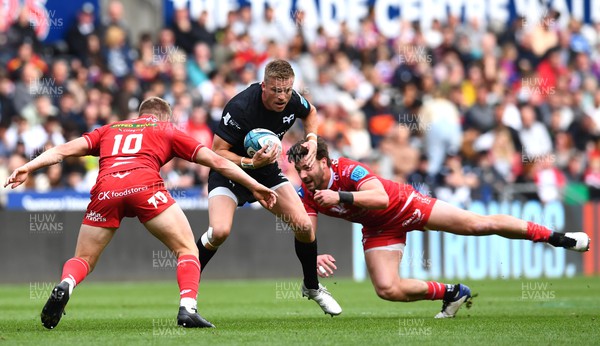 300422 - Ospreys v Scarlets - United Rugby Championship - Gareth Anscombe of Ospreys is tackled by Johnny Williams