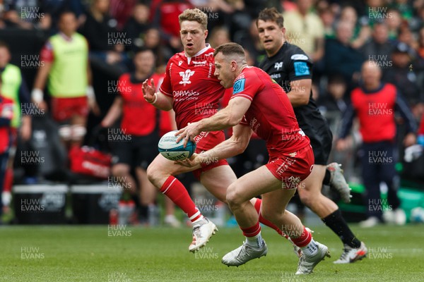 300422 - Ospreys v Scarlets - United Rugby Championship - Gareth Davies of Scarlets passes the ball to Angus O'Brien