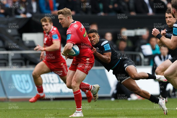 300422 - Ospreys v Scarlets - United Rugby Championship - Angus O'Brien of Scarlets is tackled by Keelan Giles of Ospreys