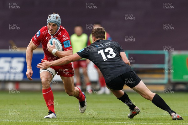 300422 - Ospreys v Scarlets - United Rugby Championship - Jonathan Davies of Scarlets is tackled by Michael Collins of Ospreys