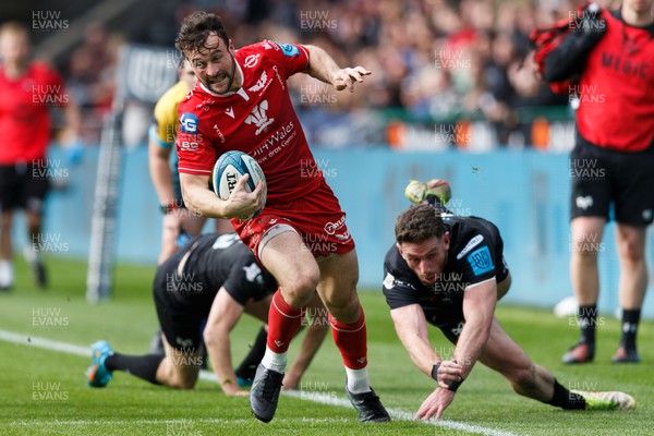 300422 - Ospreys v Scarlets - United Rugby Championship - Ryan Conbeer of Scarlets gets away from Alex Cuthbert of Ospreys