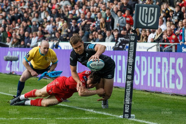300422 - Ospreys v Scarlets - United Rugby Championship - Michael Collins of Ospreys is tackled by Ryan Conbeer of Scarlets