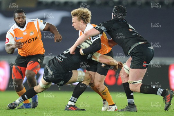 240218 - Ospreys v Toyota Cheetahs - Guinness PRO14 -  Fred Zeilinga of Toyota Cheetahs is tackled by Adam Beard of Ospreys and James King of Ospreys