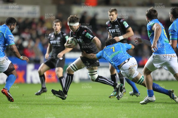 121012 Ospreys v TrevisoOspreys Ryan Jones runs through tackle by Treviso's Paul Derbyshire