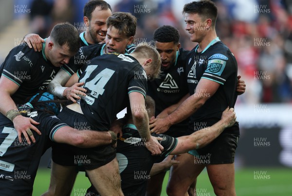 180224 - Ospreys v Ulster, United Rugby Championship - Keiran Williams of Ospreys is congratulated by team mates after scoring try