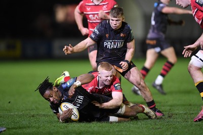 280226 - Ospreys v Ulster - United Rugby Championship - Dan Kasende of Ospreys is challenged by Nathan Doak of Ulster