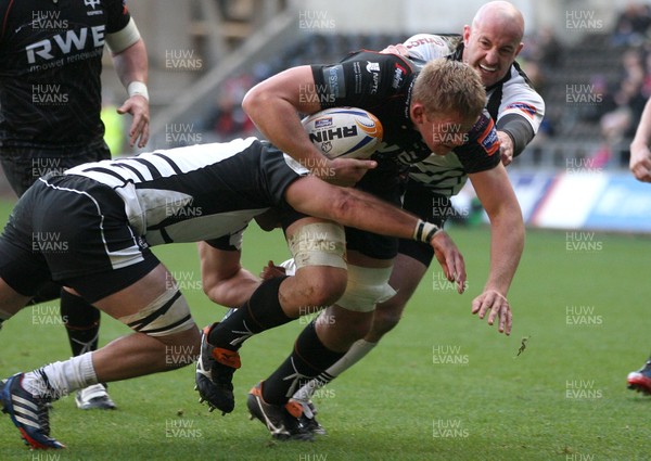 231113 - Ospreys v Zebre, RaboDirect PRO12 - Ospreys' Lloyd Peers is tackled by Zebre's Brendon Leonard and Zebre's Filippo Cristiano