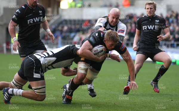 231113 - Ospreys v Zebre, RaboDirect PRO12 - Ospreys' Lloyd Peers is tackled by Zebre's Brendon Leonard and Zebre's Filippo Cristiano